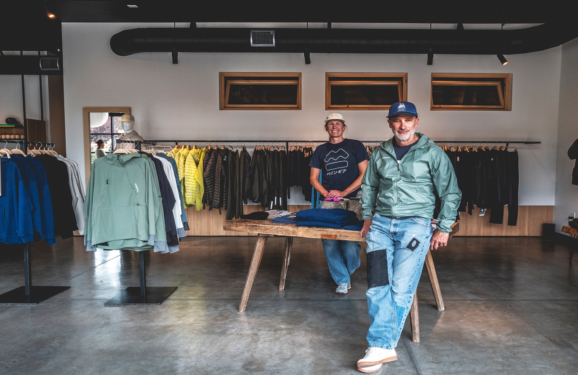 two people standing inside of a clothing store