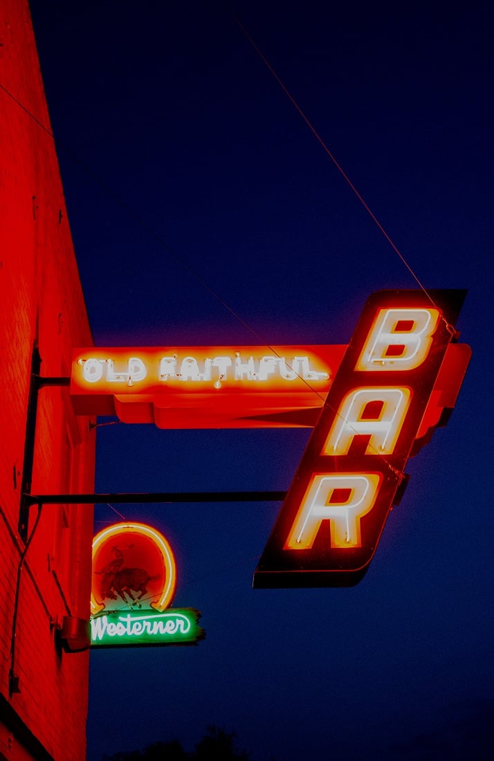 signage for Old Faithful Bar in Montana lit up at night